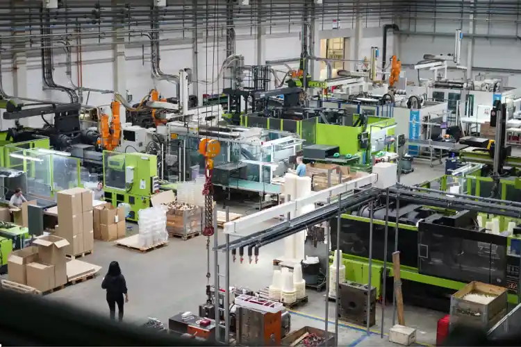PolyTALENT Personalberatung für Produktion und Industrie Produktionshalle im deutschen Mittelstand mit Maschinen, Förderband und Fachkräften im Schichtbetrieb